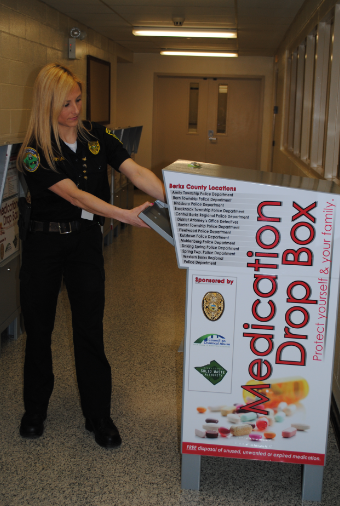 Law enforcement officer with a medication drop box